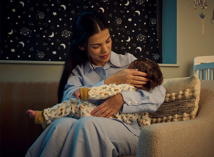 a mum holding her baby in their nursery