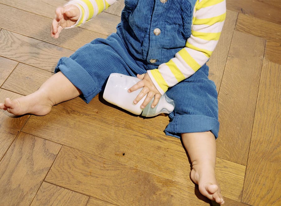 a baby holding a bottle