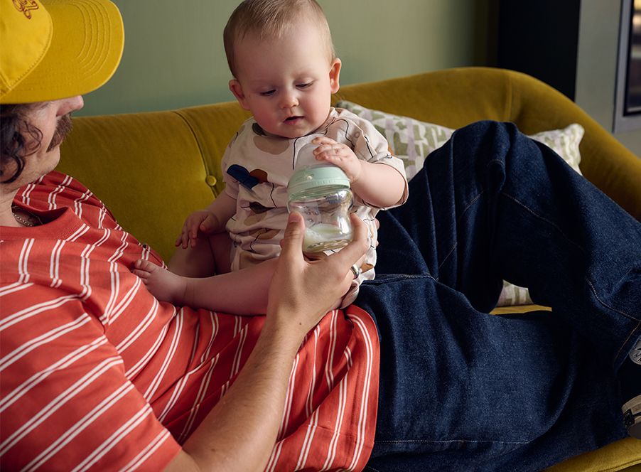 dad holding baby with bottle