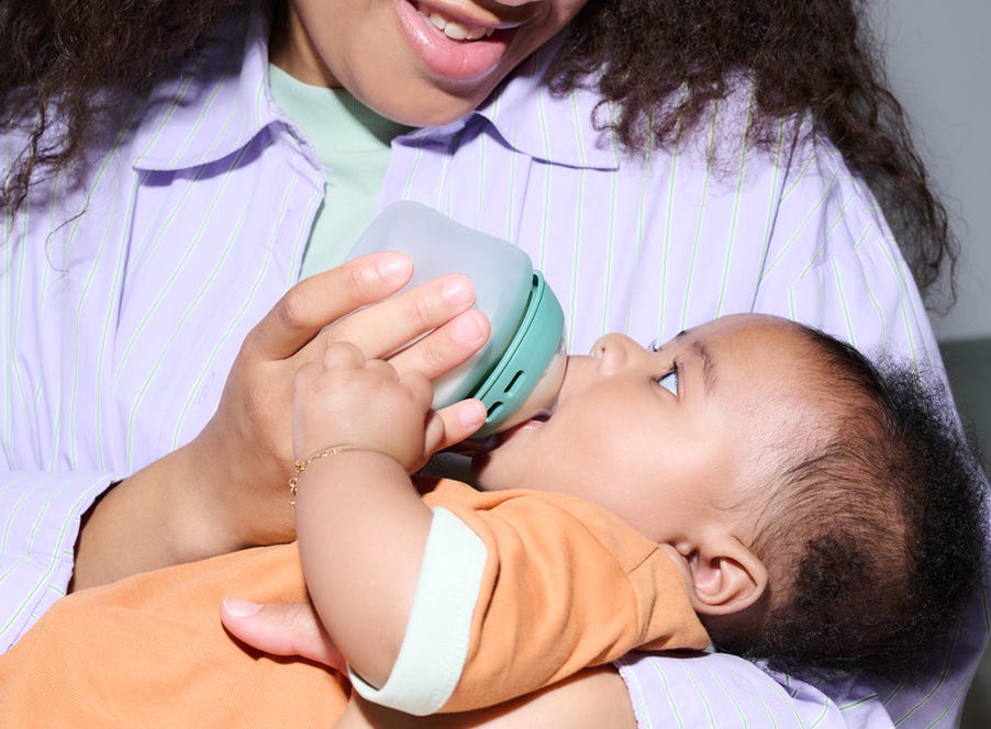 a baby feeding from a tommee tippee bottle