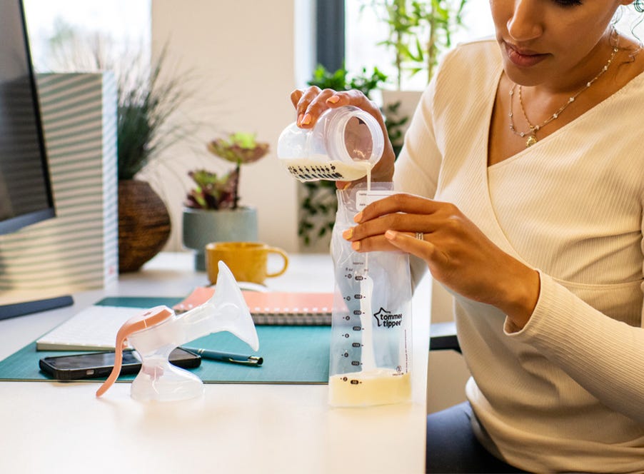 a mum using a tommee tippee breast pump while sitting at her desk