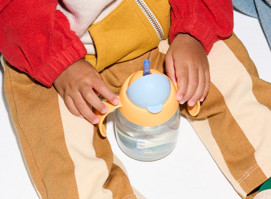 a toddler drinking from a tommee tippee cup