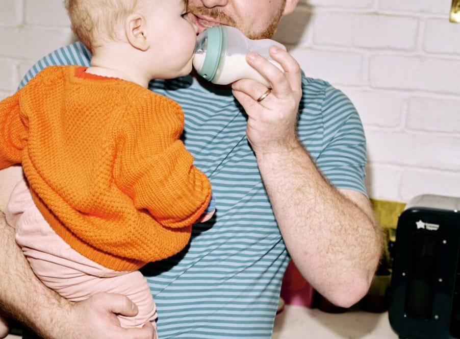 a dad bottle feeding his baby