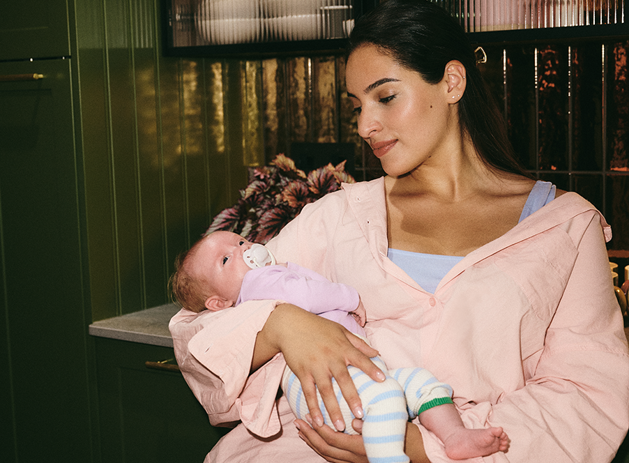 mum in pastel coloured clothing holding young baby