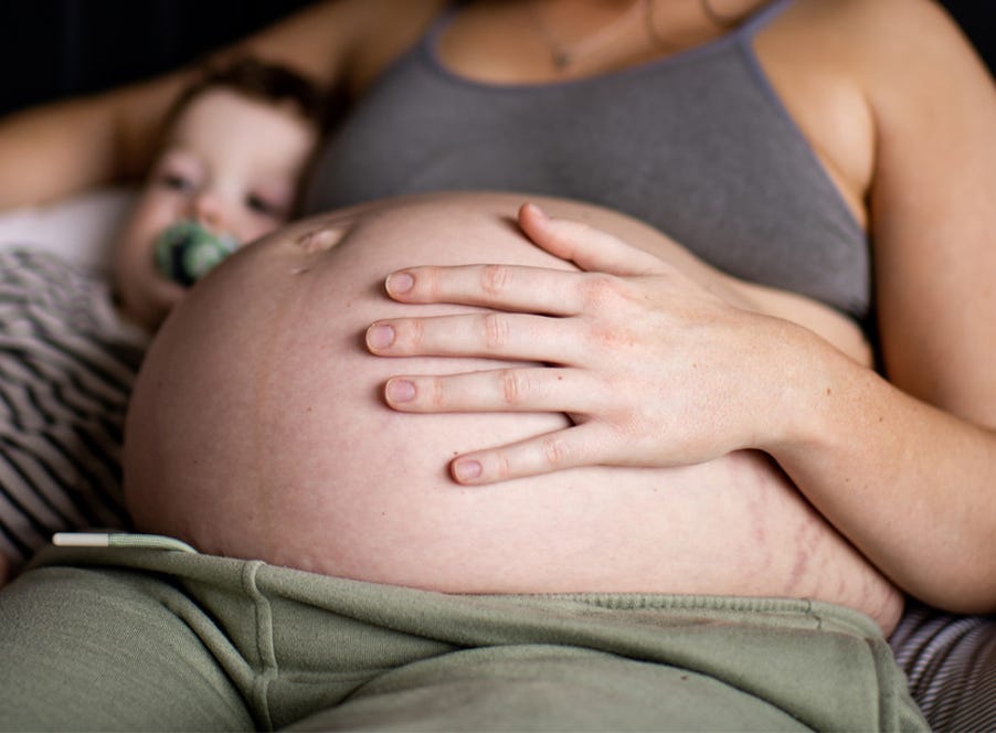 a pregnant mom holding her baby bump