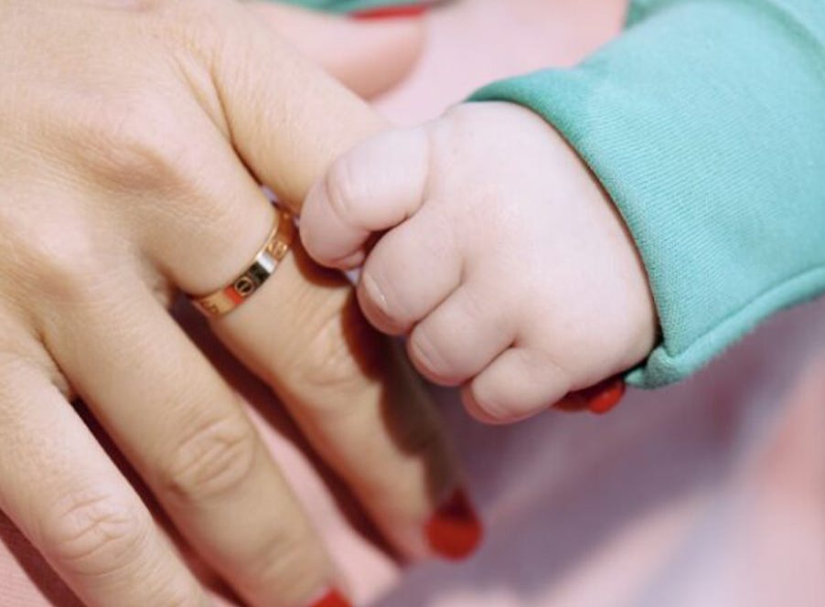 a mum and baby holding hands