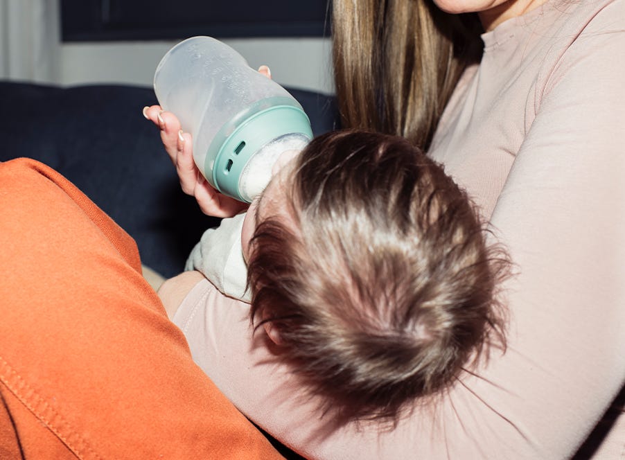 a mom bottle feeding their baby
