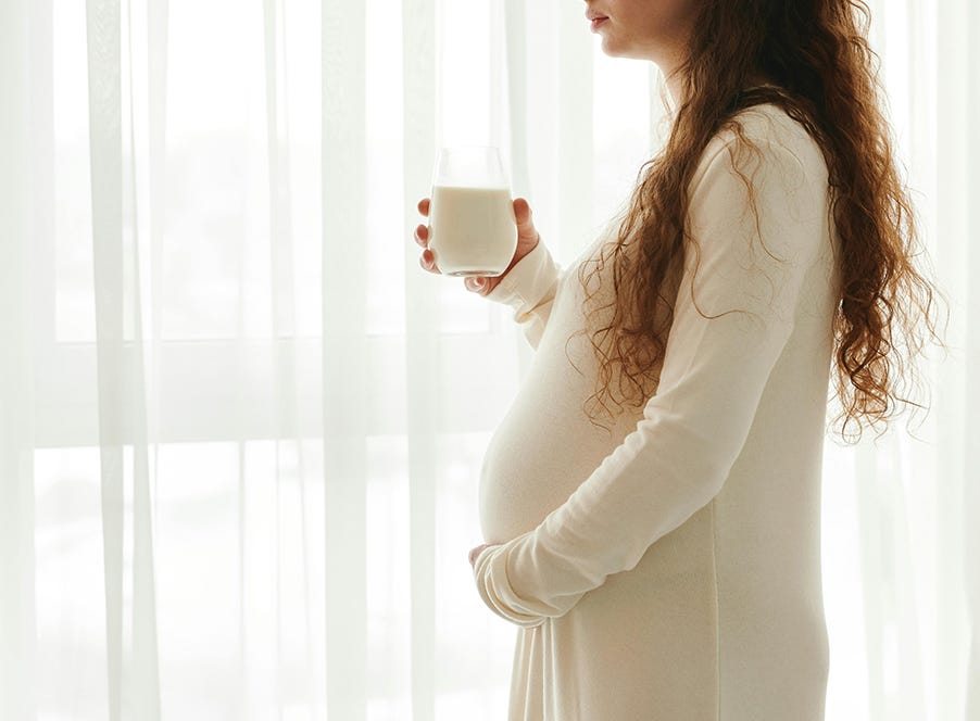 a pregnant woman standing in front of a window