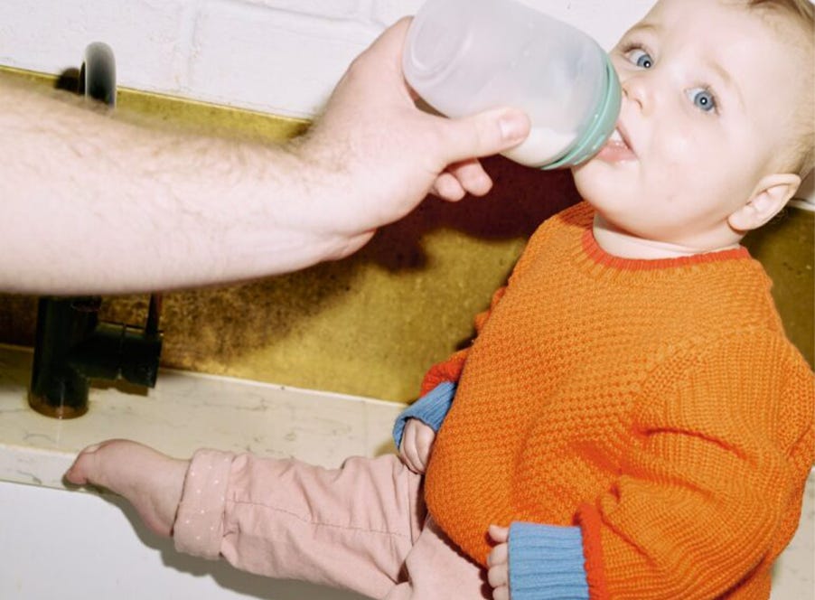 a dad bottle feeding his baby