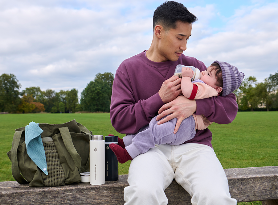 dad feeding baby outside