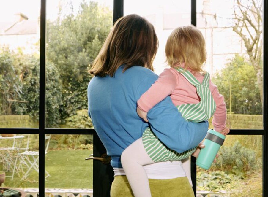 a mum looking out the window with her toddler