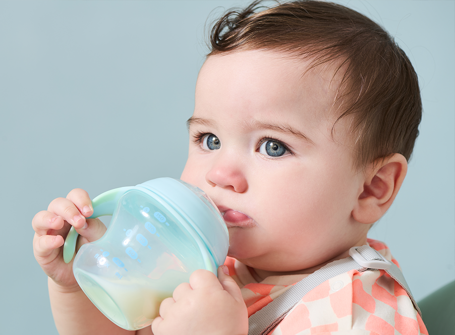 a toddler holding a blue cup