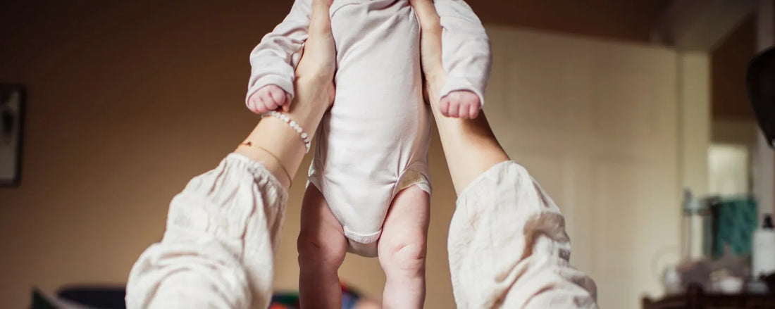 Une maman qui tient son bébé en l'air