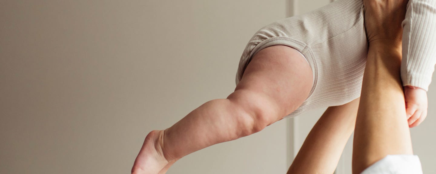 Une maman qui tient son bébé en l'air