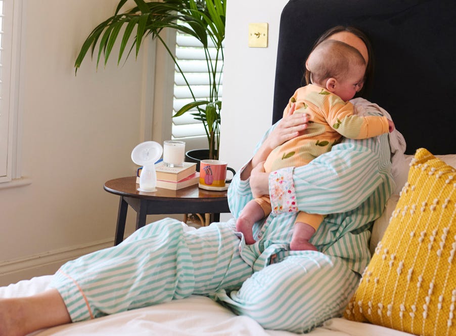 a mum sitting on her bed holding her baby