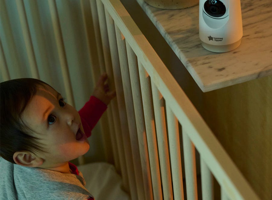 a baby in their cot being watched by a baby monitor