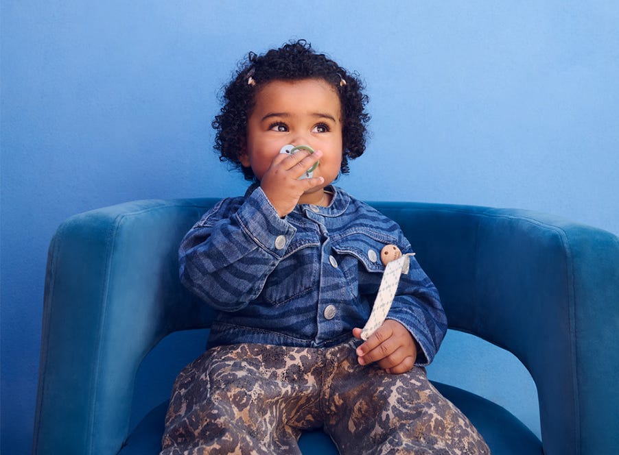 a toddler sitting on a blue chair