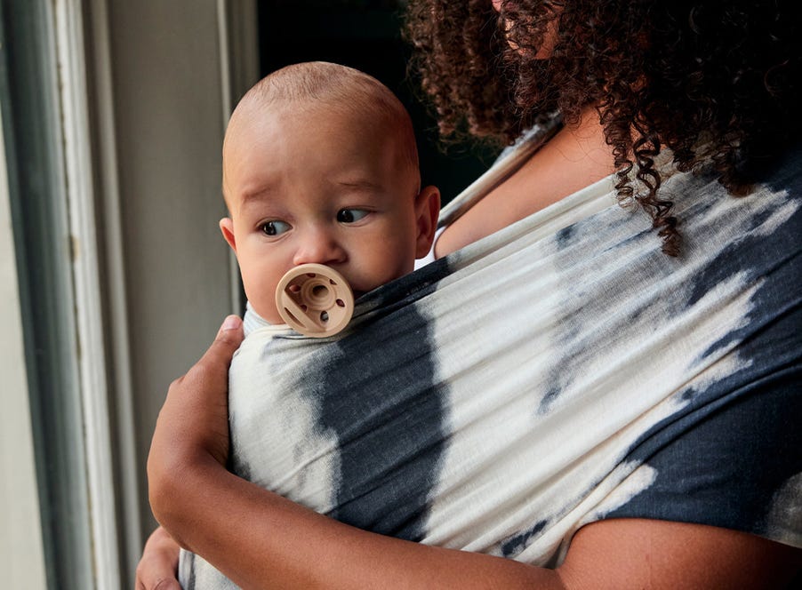 a mum carrying her baby in a sling