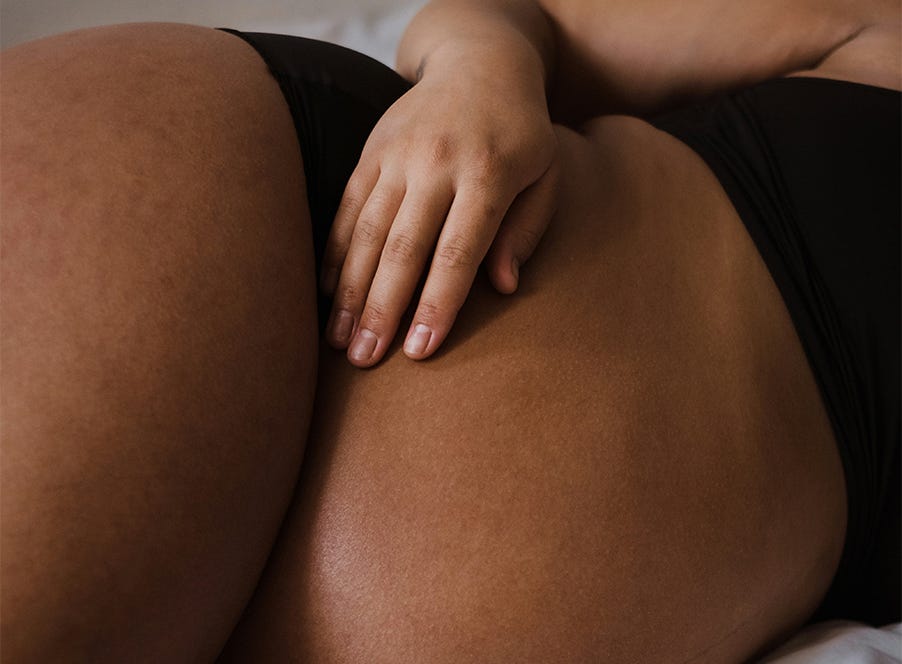 a pregnant woman holding her baby bump