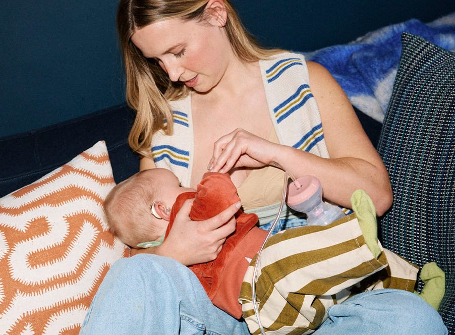 mum breastfeeding her baby while using a breast pump