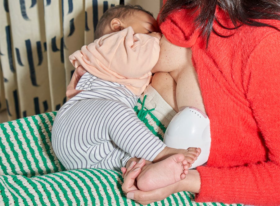a woman using a tommee tippee breast pump and breastfeeding