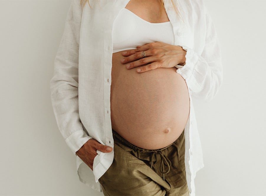 a pregnant woman wearing a white shirt