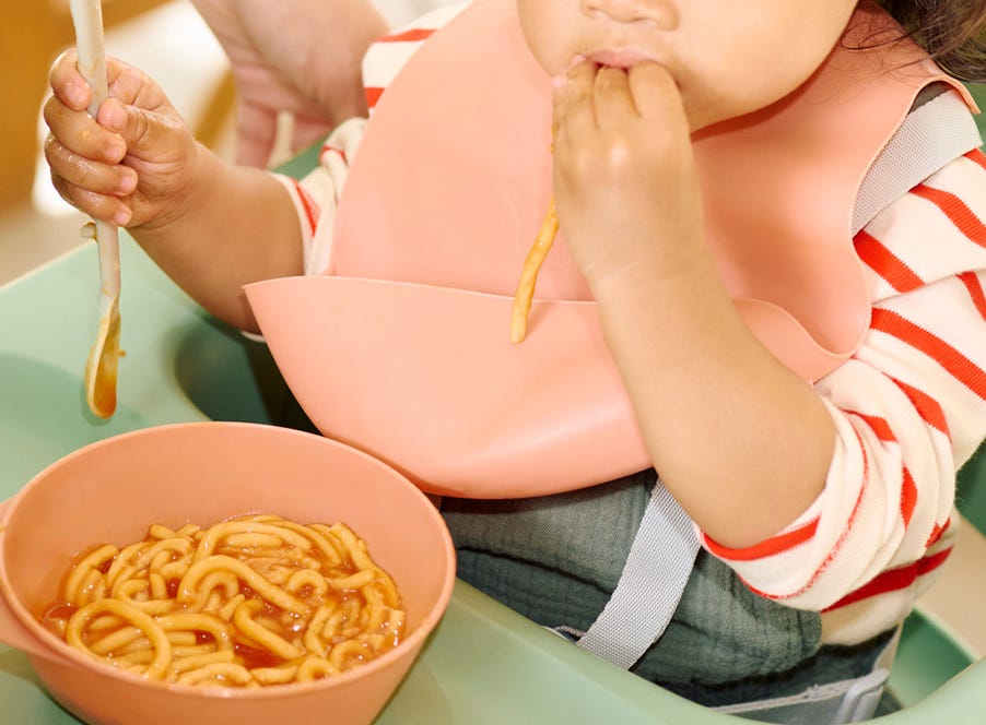 a baby eating wearing a tommee tippee bib