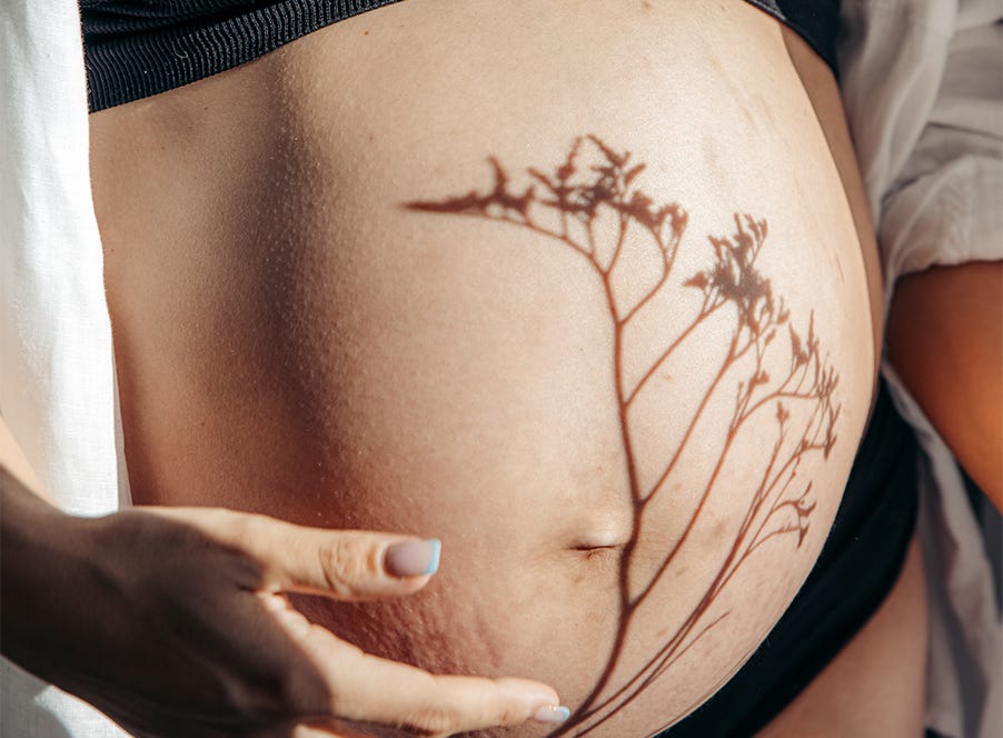 a pregnant woman holding her baby bump