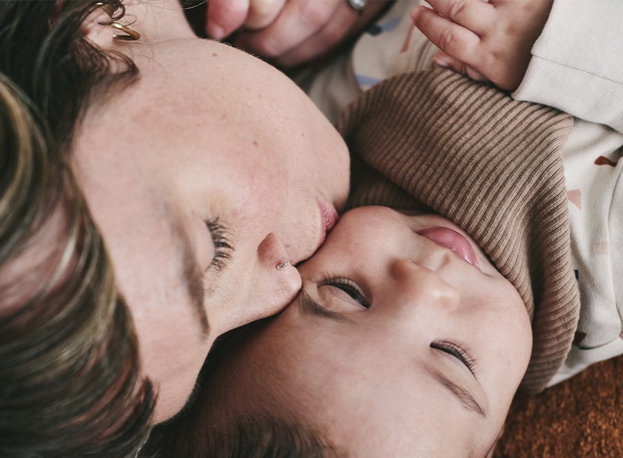 a mom kissing her baby