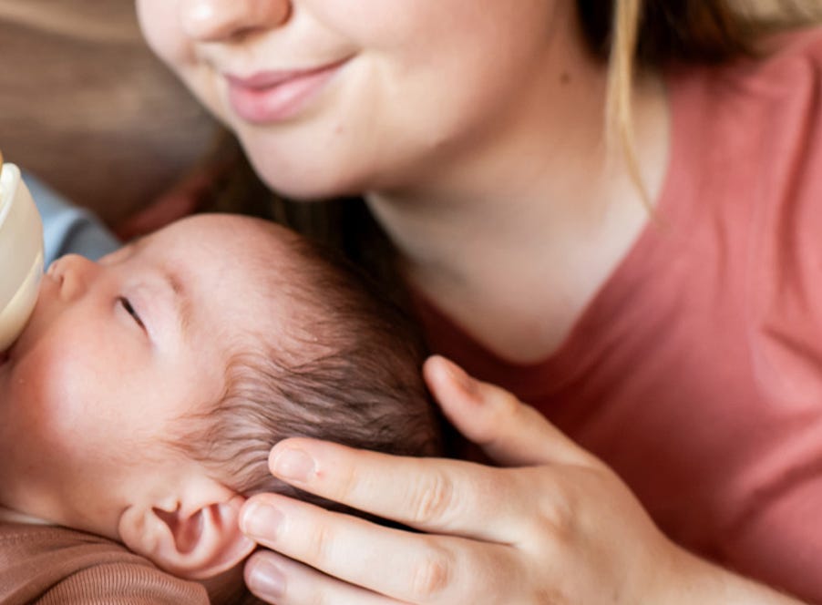 a mum looking at her bottle feeding newborn