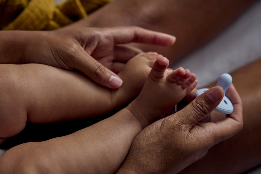 Close-up of baby on mum's lap while she holds their feet..