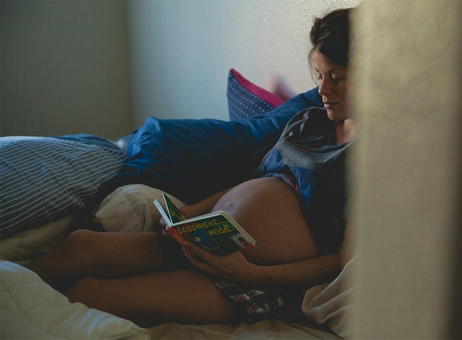a pregnant woman reading a book
