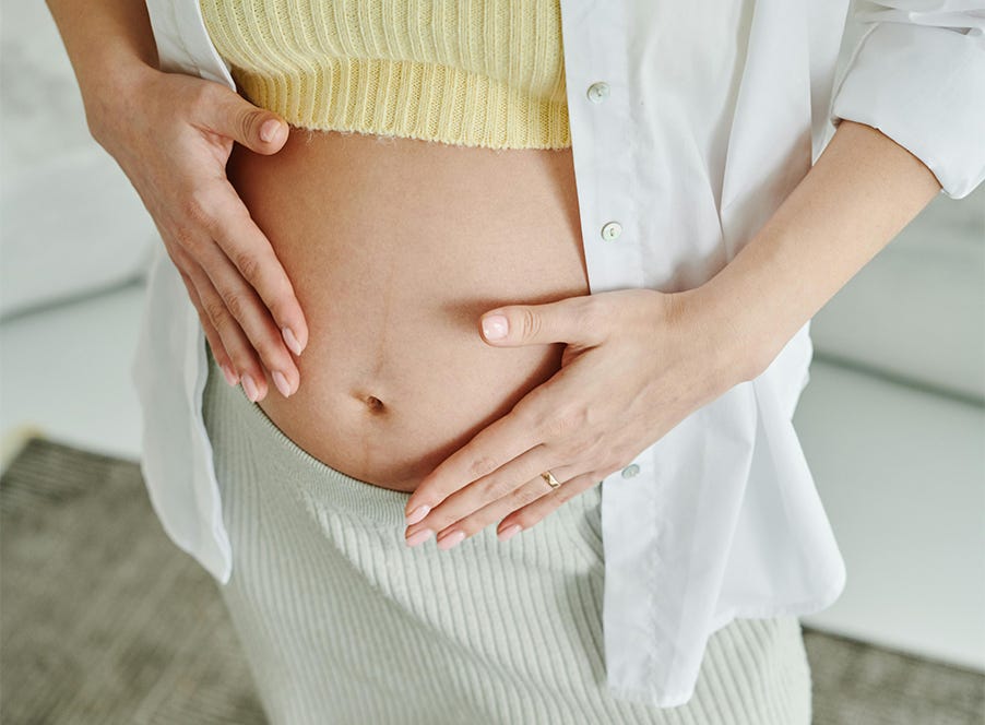 a pregnant woman holding her baby bump