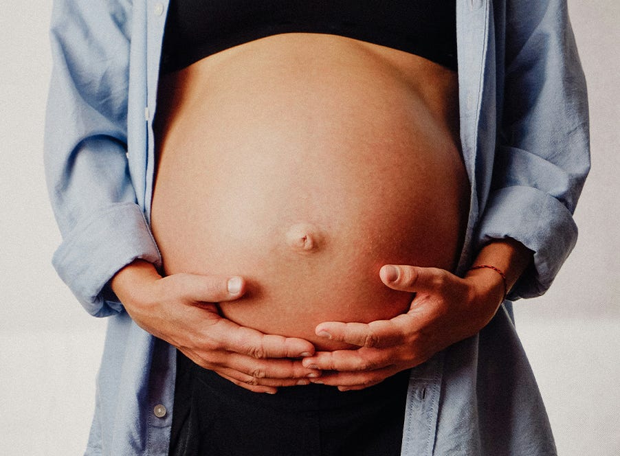 a woman holding her baby bump