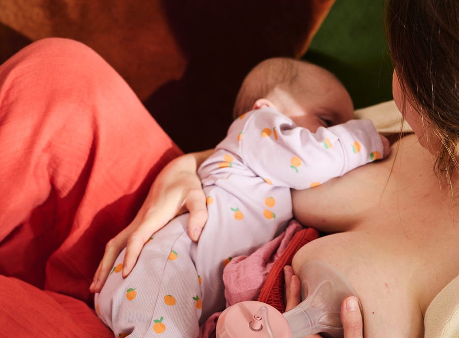 a mum breastfeeding her baby and using a tommee tippee breast pump