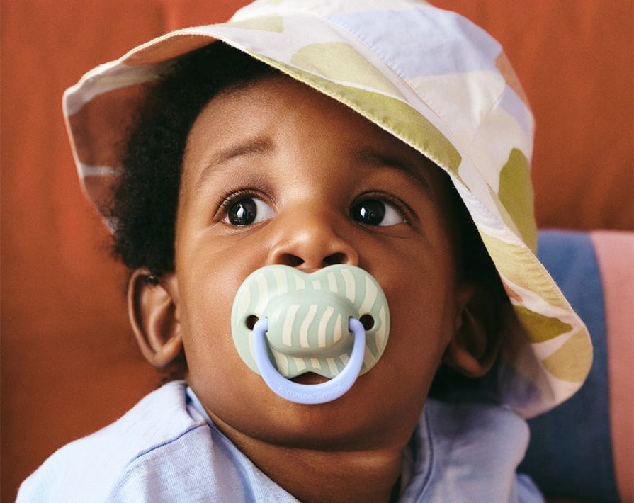 a baby putting a tommee tippee dummy in their mouth