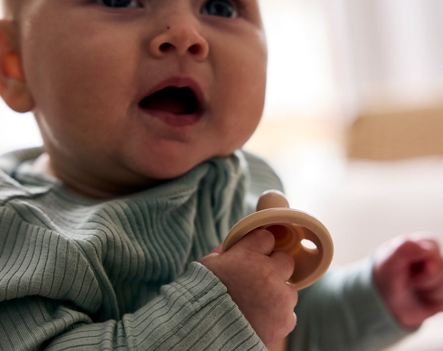 a baby holding a tommee tippee soother