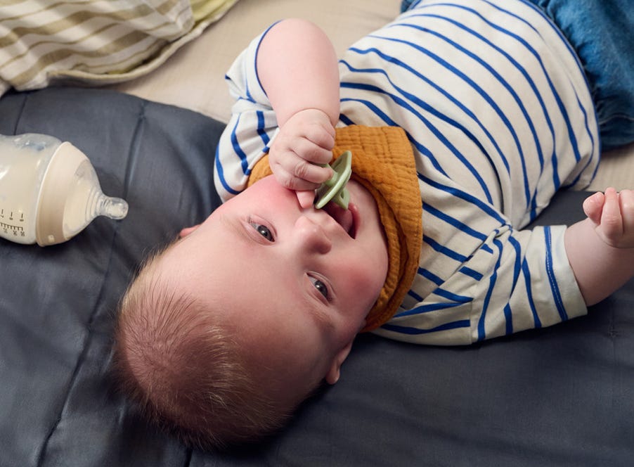 a baby chewing their soother