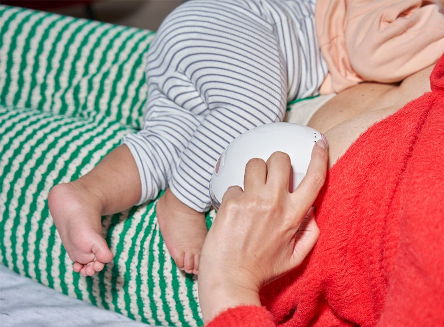mum breastfeeding her baby while using a wearable breast pump