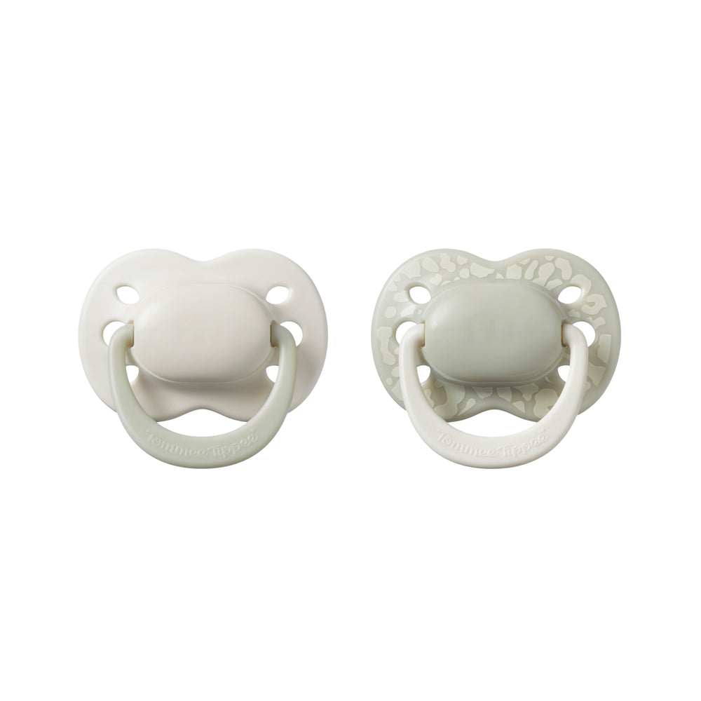Two white baby pacifiers on a white background