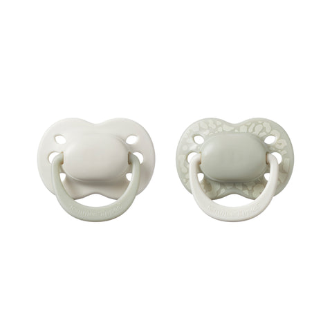Two white baby pacifiers on a white background