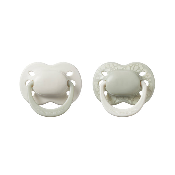 Two white baby pacifiers on a white background