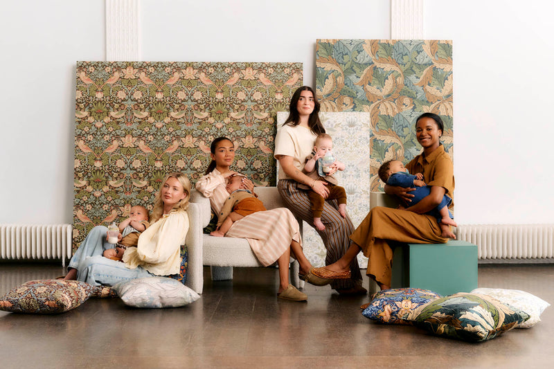 mums with babies sitting in room with decorated backdrop