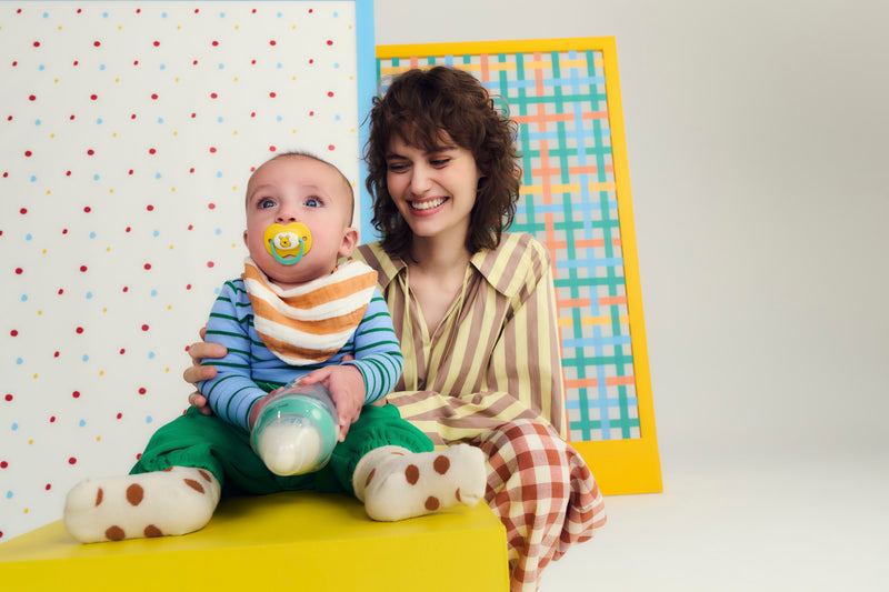 woman sitting behind baby smiling