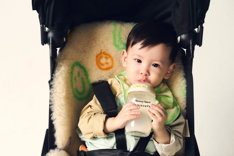 baby drinking from bottle in buggy