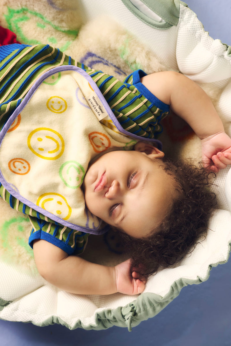 baby asleep with arms up, wearing bib