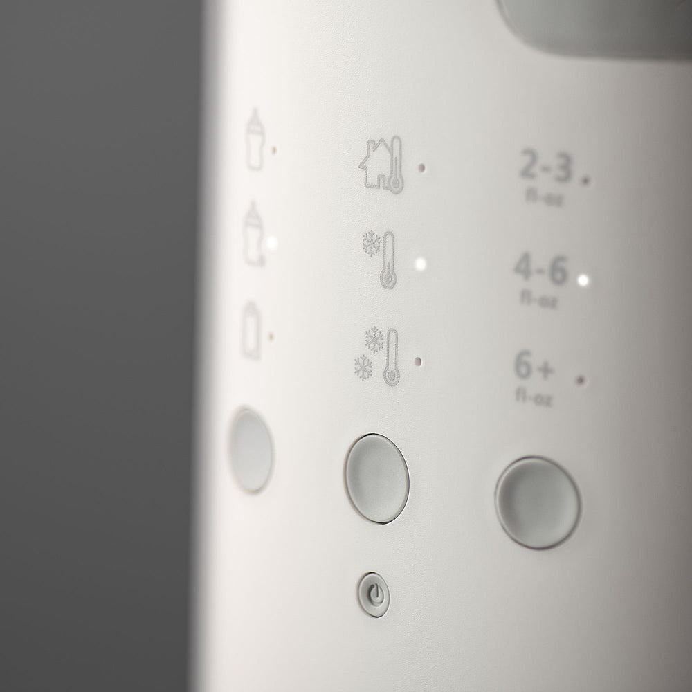 Close up image of the buttons on a Multiwarm bottle warmer against a grey background