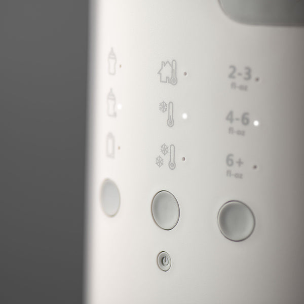 Close up image of the buttons on a Multiwarm bottle warmer against a grey background