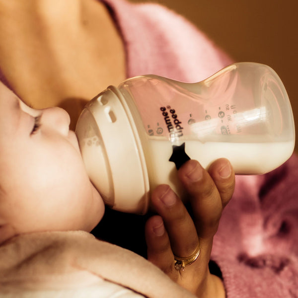 Woman feeding a baby using a Natural Start bottle
