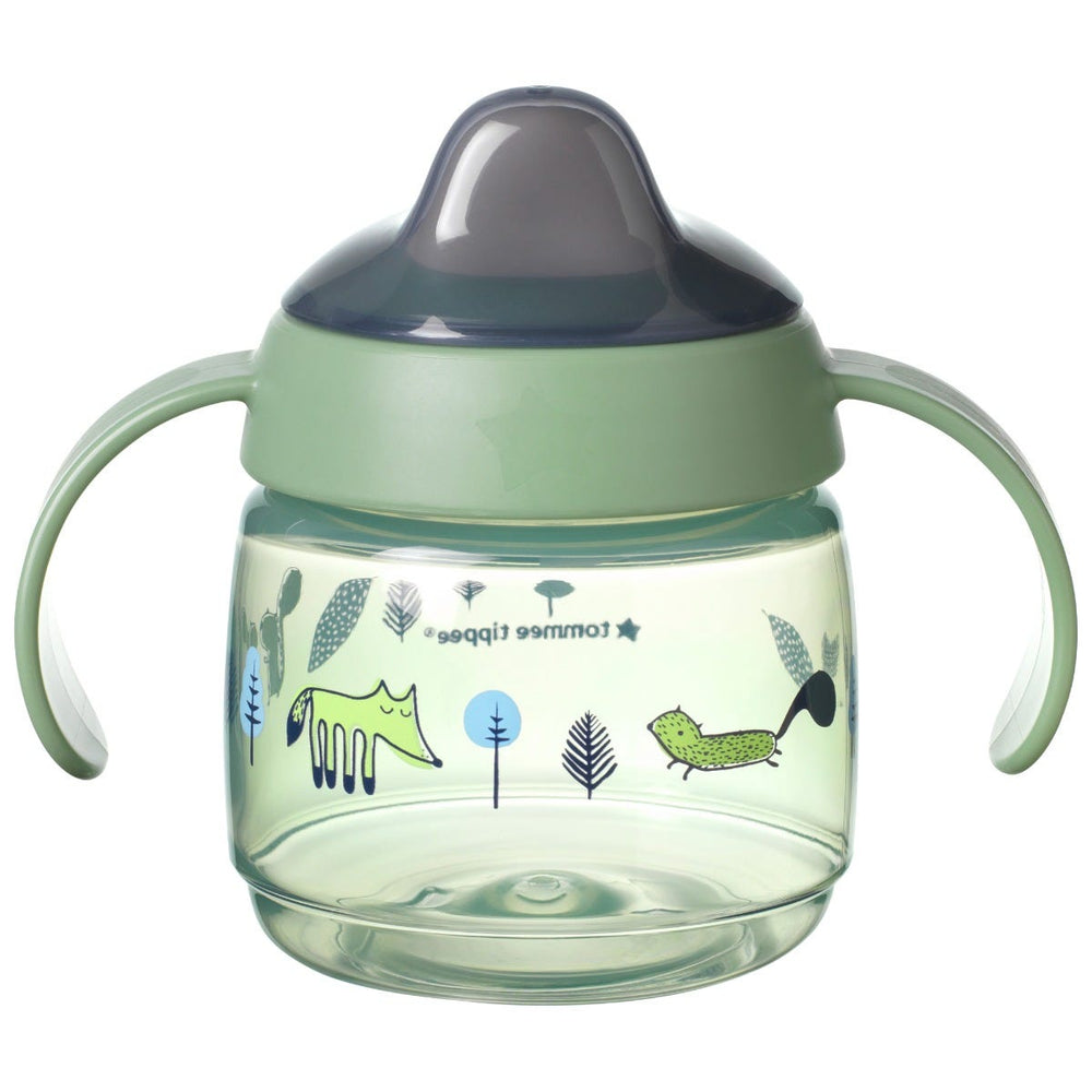 Tasse d'apprentissage verte sur fond blanc